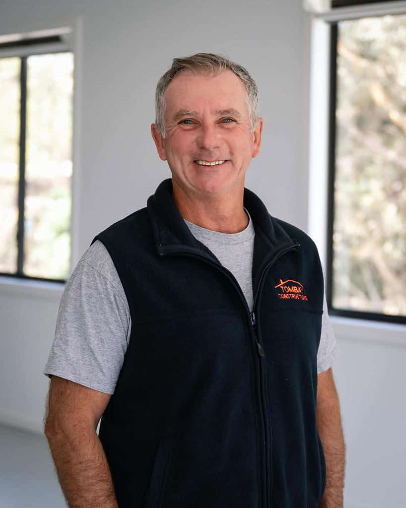 Professional construction worker smiling in an indoor setting.